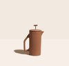 A Matte Sand Ceramic French Press on a cream background.