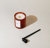 The Candle Snuffer next to the Castillo Double Wall Candle on a grayish background.