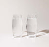 Two 16 oz Clear Century Glasses filled with water on a cream background. 