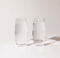 Two 16 oz Clear Century Glasses filled with water on a cream background. 