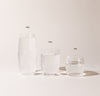 A 16 oz , 12 oz and 6 oz Clear Century Glasses lined up on a cream background. 