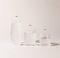 A 16 oz , 12 oz and 6 oz Clear Century Glasses lined up on a cream background. 