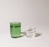 A 12 oz Verde and 6 oz Clear Century Glass filled with water on a cream background