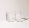 Two 12 oz Clear Double Wall Glasses on a cream background. 