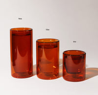 A 16 oz , 12 ox and 6 oz Amber Double Wall Glass on a cream background. 