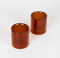 Two 6 oz Amber Double Wall Glasses on a cream background. 