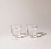 Two 6 oz Clear Double Wall Glasses on a cream background. 