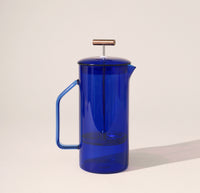 A Cobalt Glass French Press on a cream background.