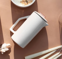An overhead shot of the  Gloss Cream Ceramic French Press on a brownish background. 
