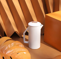 A Gloss Cream Ceramic French Press on an orange background.