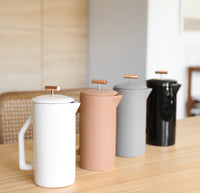 Side view of the Gloss Cream Ceramic French Press lined up with A Matte Sand and A Matte Gray Ceramic French Press 