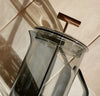 A side view of the Gray Glass French Press on a cream background. 